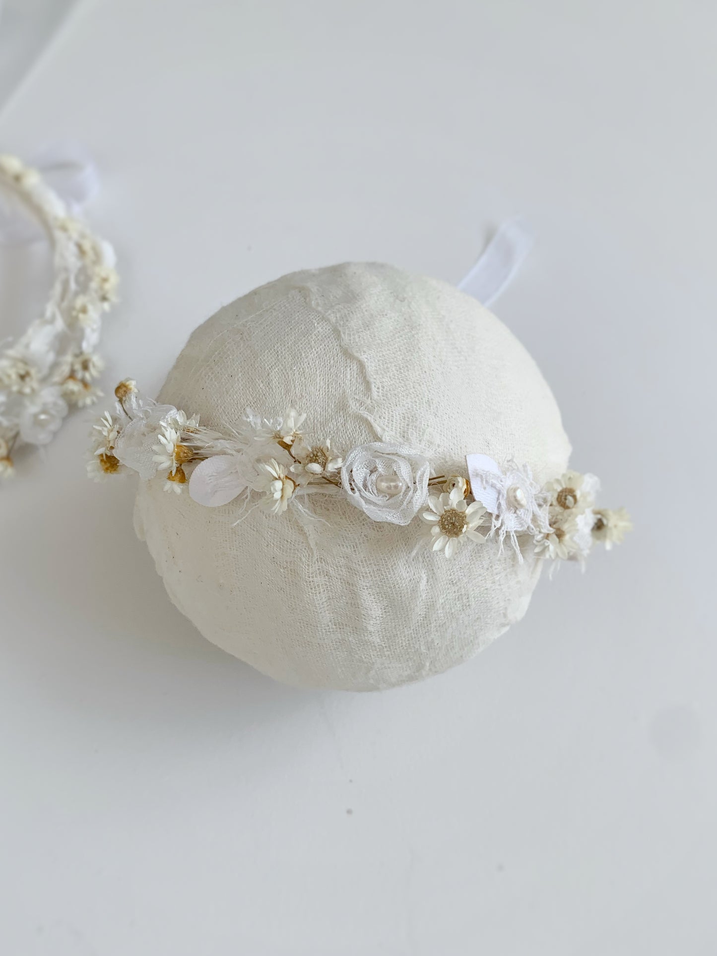Close-up of floral baby crown with chiffon and preserved daisies