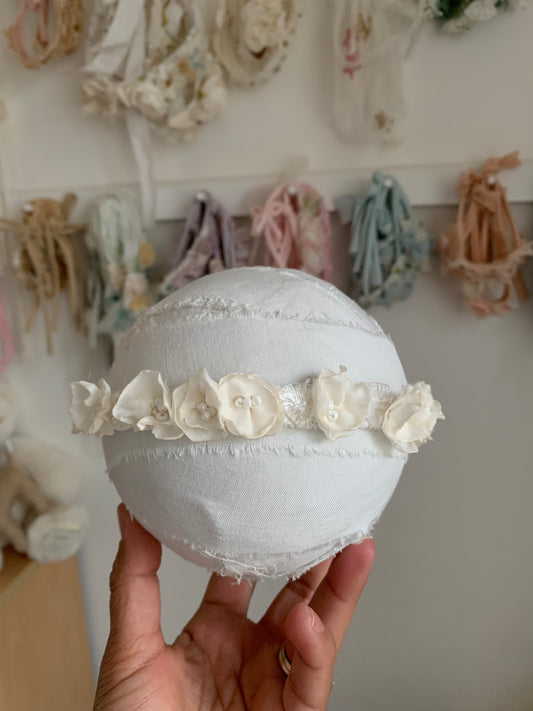 Ivory baby flower crown headband on a ball on my hand to show size.