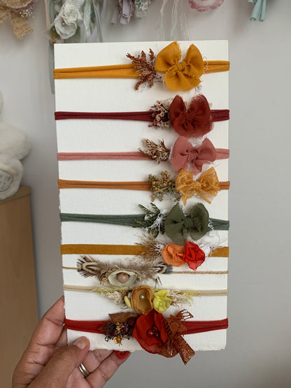 a person holding a card with all the headbands designs on it to show size of them 