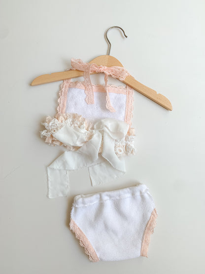 Boho newborn baby girl outfit set showing hrte open back detail on the top on a wooden hanger