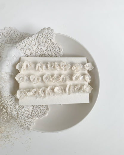ivory baby floral crown headband with chiffon flowers and beads on a white card and decoratibve vintage lace doily 
