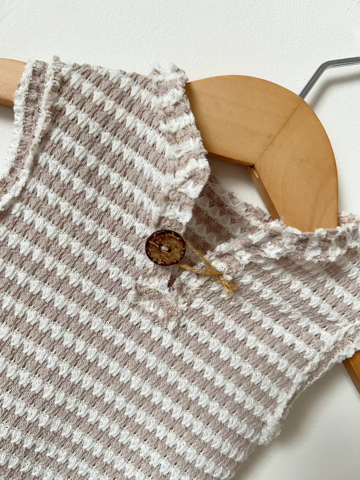 close up of the button on the beige romper 