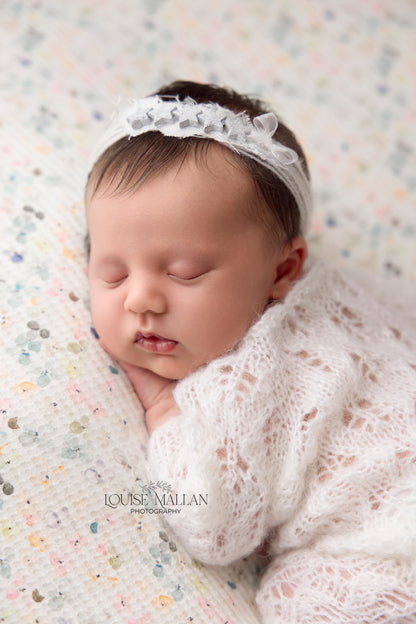 baby wearing a delicate headband in white with little stars