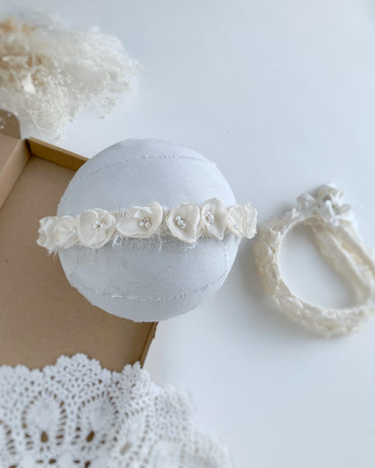 ivory baby flower crown headband on a foam ball and inside a brown box 
