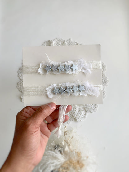 a hand holding a white card with the headbands attached to them to show size
