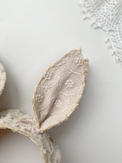 Close-up of lace bunny ears inspired headband in soft beige lace material

